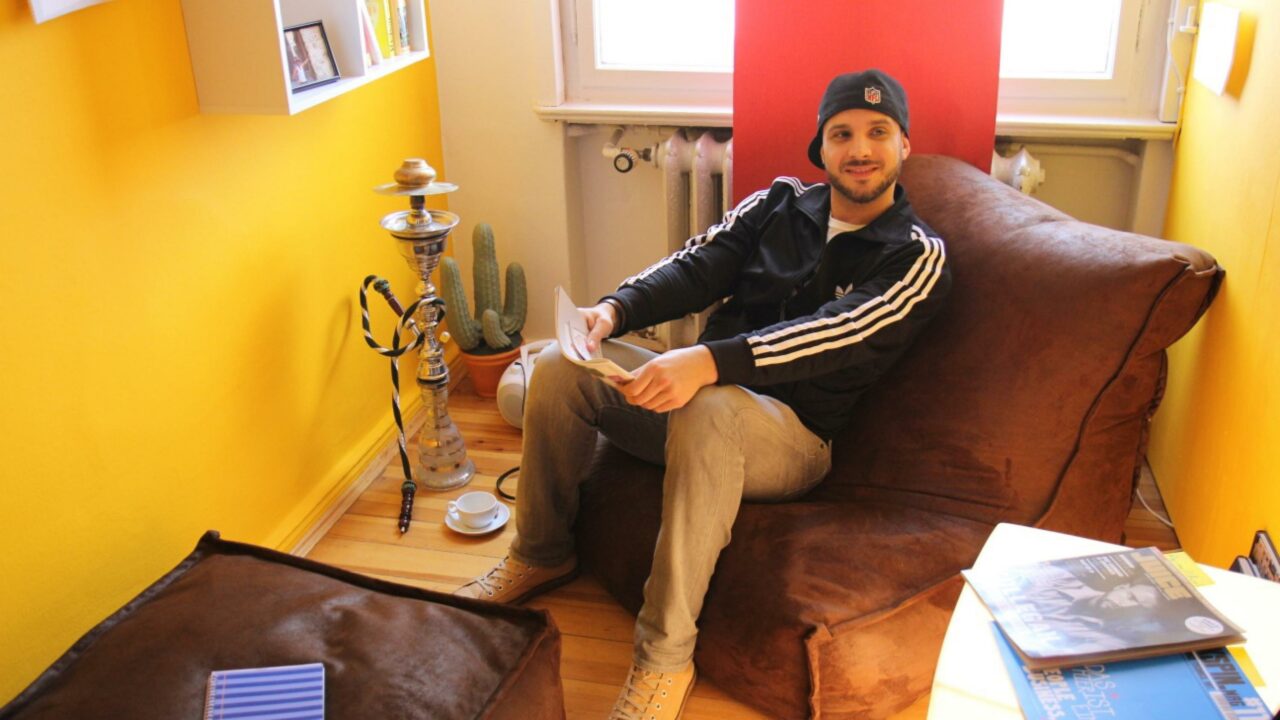 Ein Pressebild vom VillaGlobal. Auf dem Bild ist der Gründer Jonni von Villa Global zu sehen, wie er auf einem Sessel sitzt.